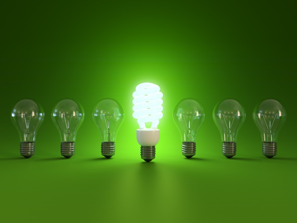 Energy saving and simple light bulbs isolated on green background.